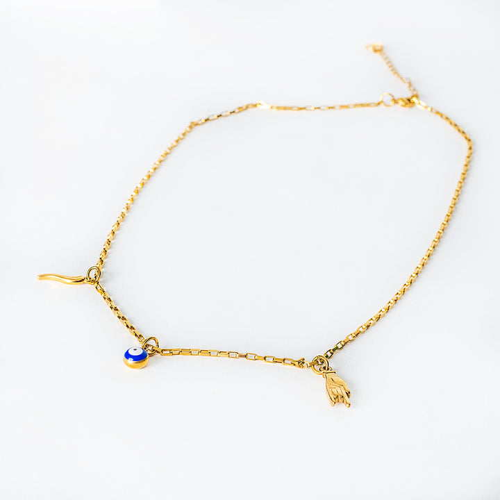 A full-screen view of Xorti necklace with a blue charm and a small gold object on a white background