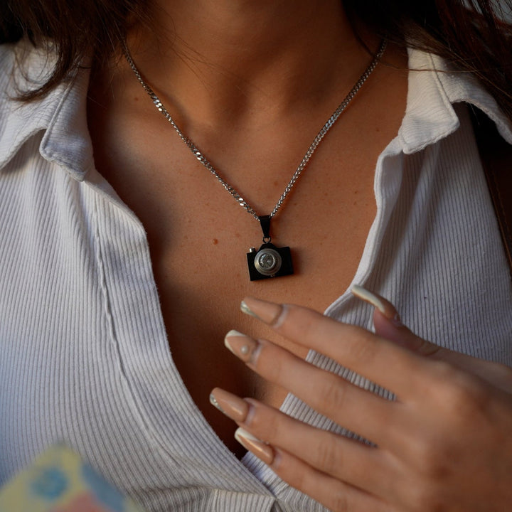 woman wearing The Photographer Necklace with her white t-shirt and backpack. 