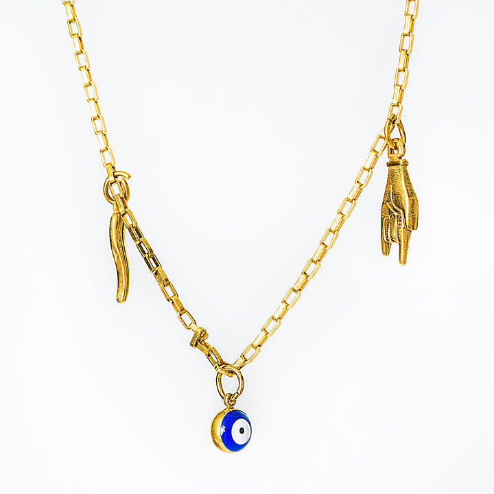 Gram Collections Xorti's gold necklace with a blue evil eye charm on a white background