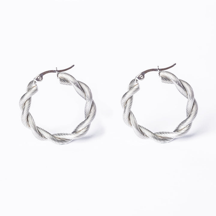 An side by side view of Yanica silver earrings standing in the center of the image, against a white background. 
