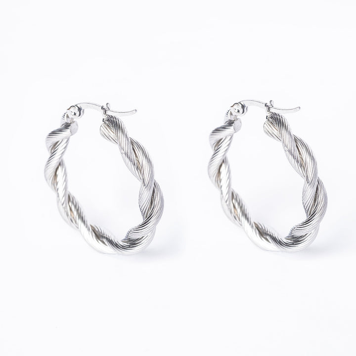 A pair of silver Yanica hoop earrings on a white background