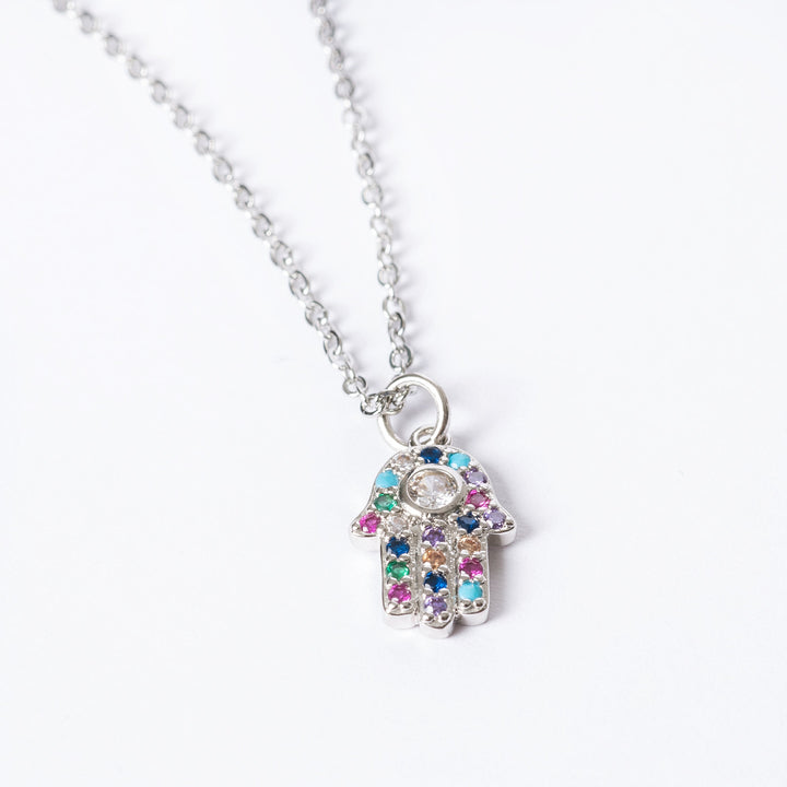 A  close up view of The Hamsa Necklace standing in the center of the image against a white background. 