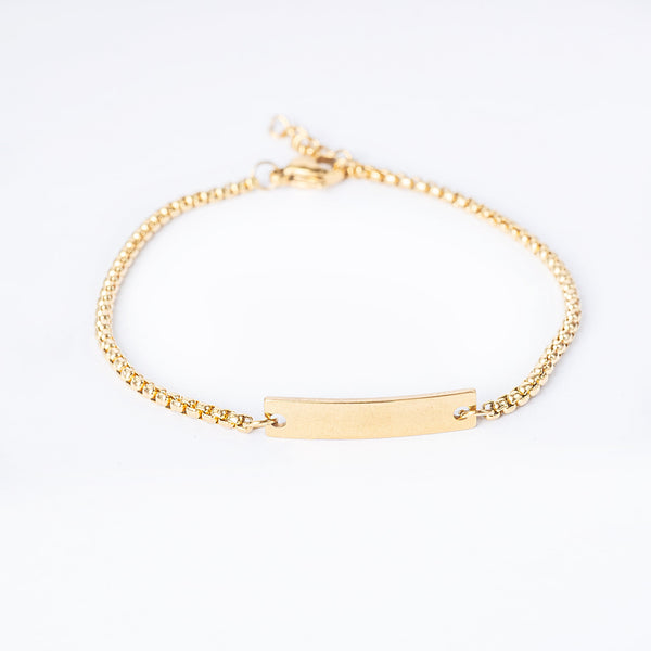 A yellow gold-plated stainless steel Alex bracelet with a minimalist design, featuring a gold-plated chain and a rectangular gold-plated bar as the clasp.
