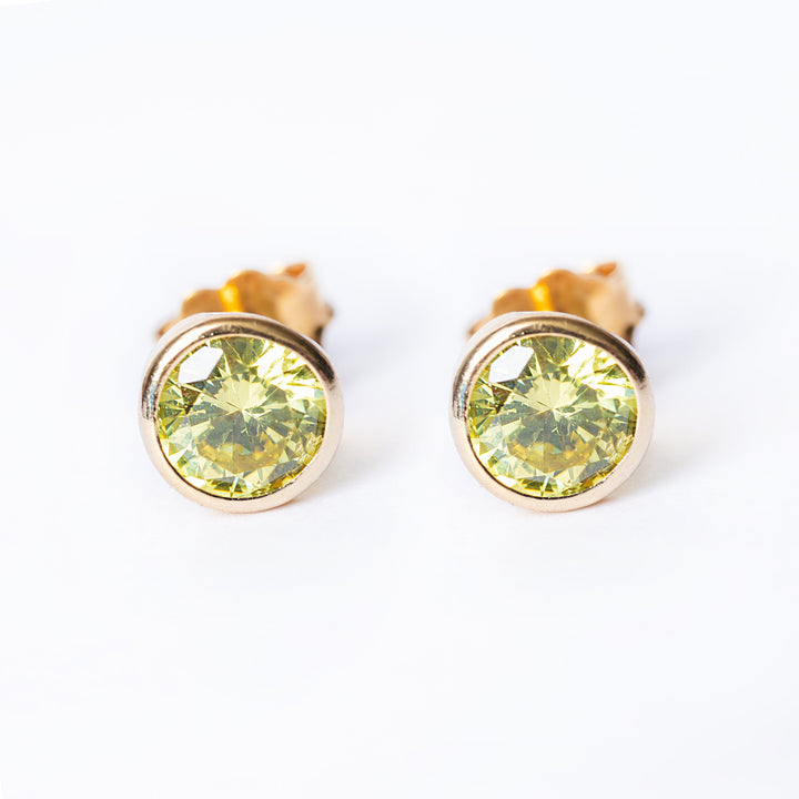 An august bithstone earring standing in the center of the image seeing from a front view.