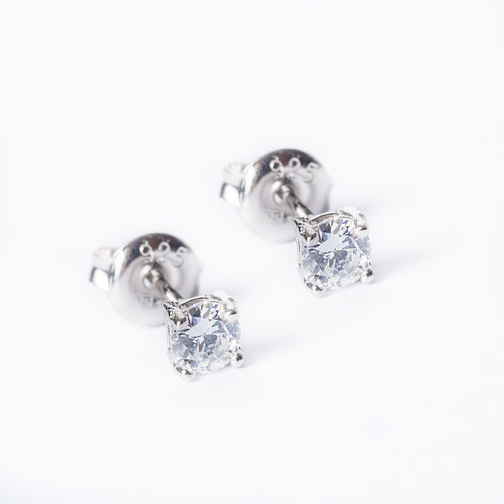 Classic Solitaire Earrings standing in the center of the image, against a white background. 