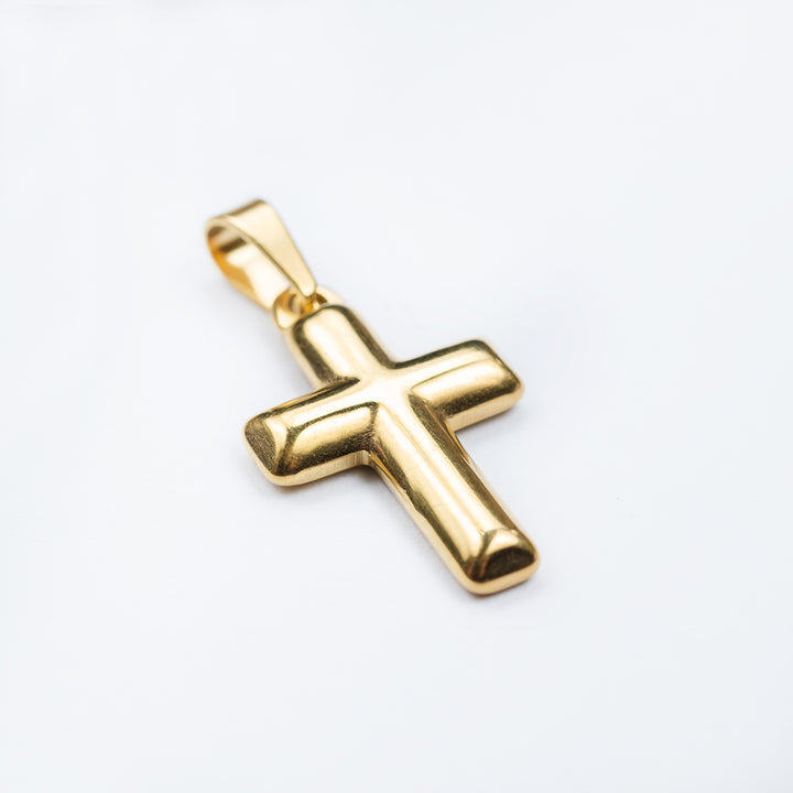 A close up side view of Gold Embossed Cross Pendant standing in the center of the image against a white background. 