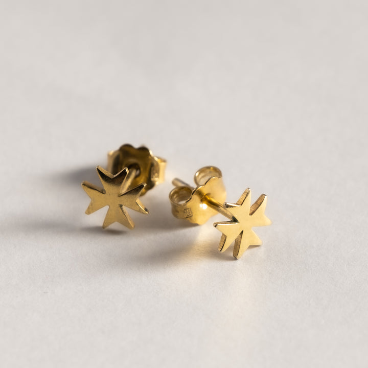 A close up view of Malta Cross Gold Stud standing in the center of the image against a white background 