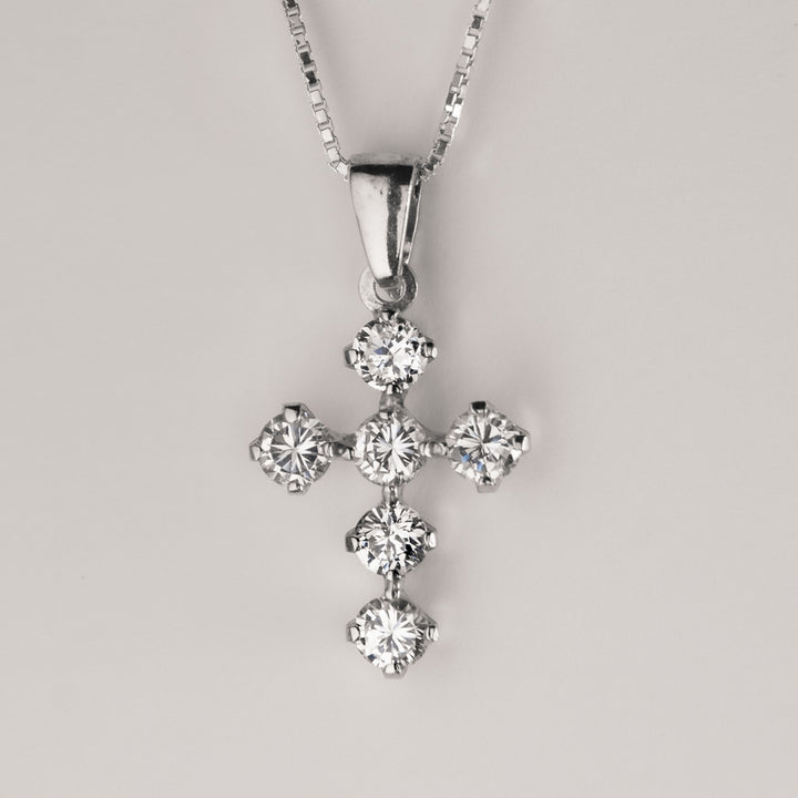 A close up view of Silver White Zircons Cross Pendant standing against a white background. 