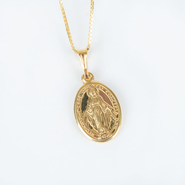 A close up view of holy mary medal double sided pendant standing in the center of the image against a white background. 