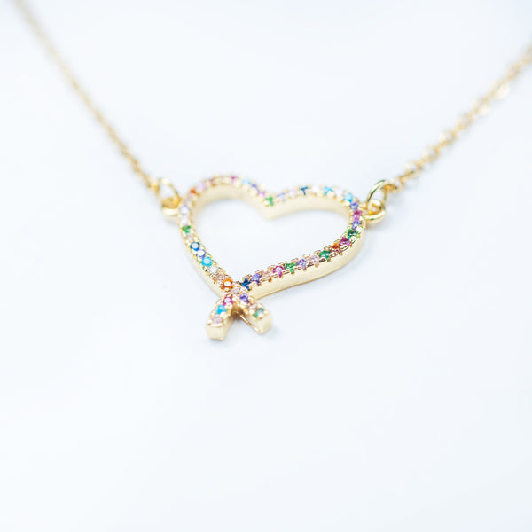 A gold-plated stainless steel necklace with a heart-shaped pendant featuring multicolored cubic zirconia.