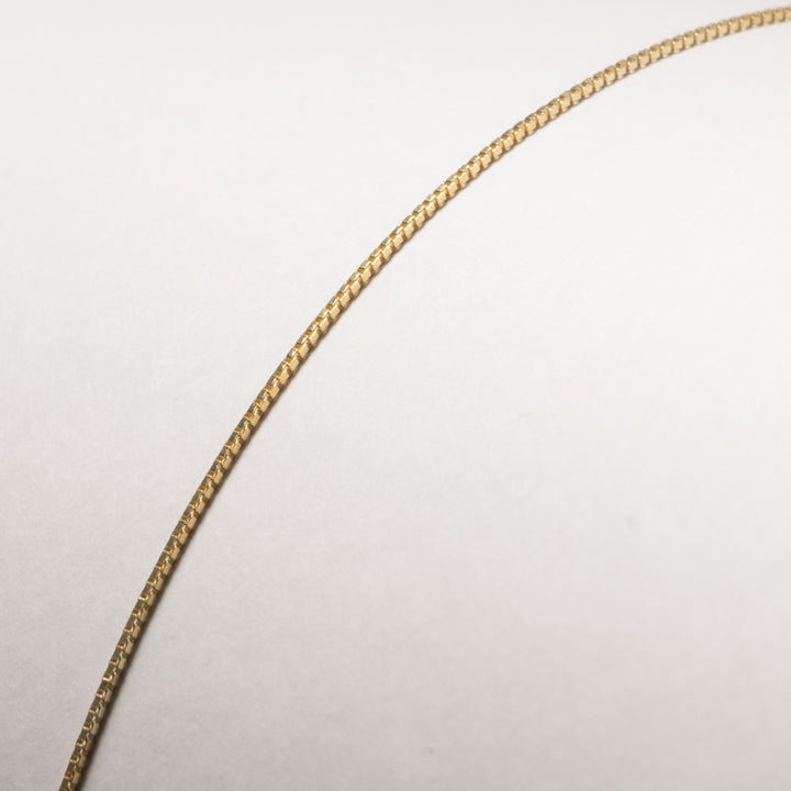 A close up view of Silver Yellow Gold Chain standing in the center of the image against a white background. 