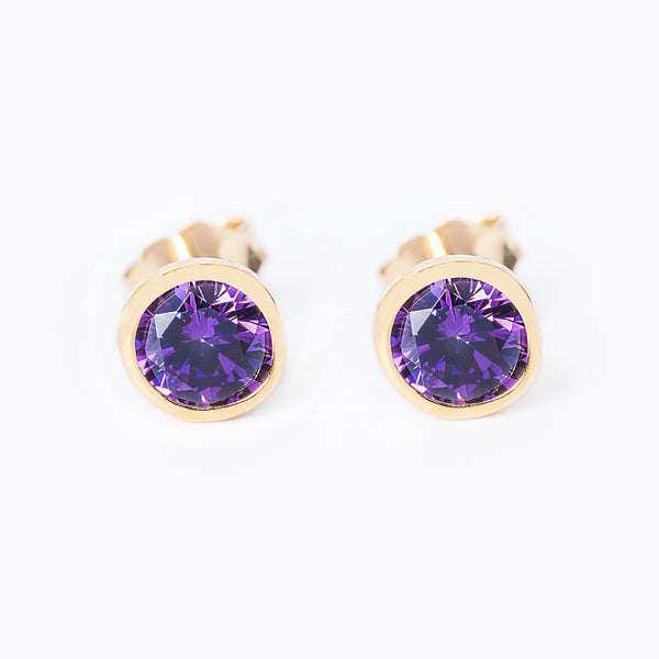A pair of gold-plated sterling silver stud earrings with a purple amethyst gemstone center.