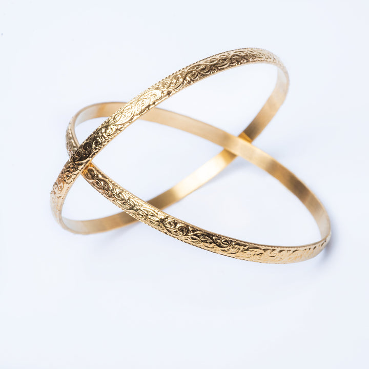 A detailed view of Fili Designed Bangles standing in the center of the image against a white background