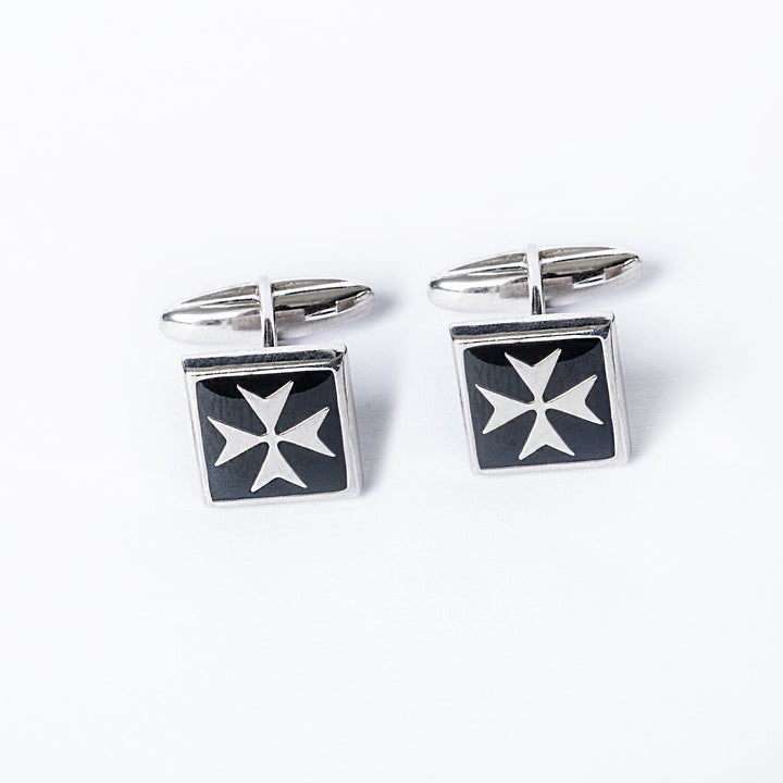 A pair of silver cufflinks with a black enamel Maltese cross design on a white background.