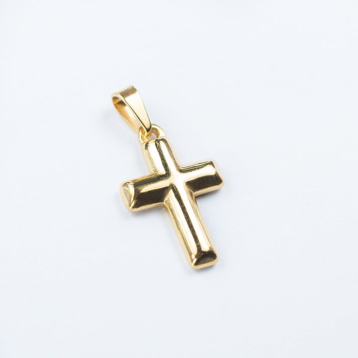 A close up view of Gold Embossed Cross Pendant standing against a silver background. 