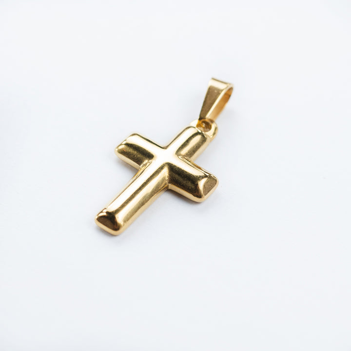side view of Gold Embossed Cross Pendant standing in the center of the image. 