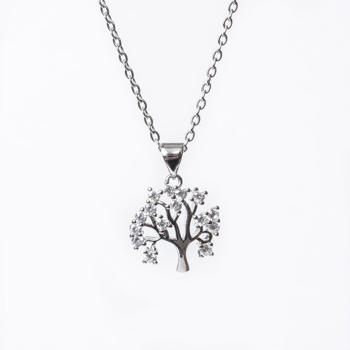 A close up view of Tree Of Life Necklace standing in the center of the image against a white background. 