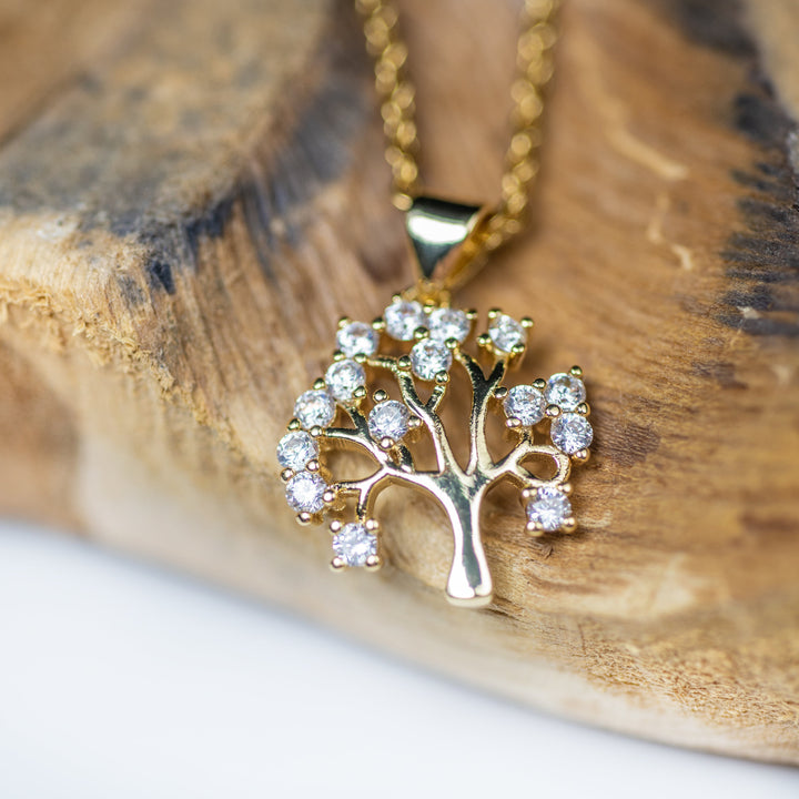 A close up view of Tree Of Life Necklace standing attached on the wood. 