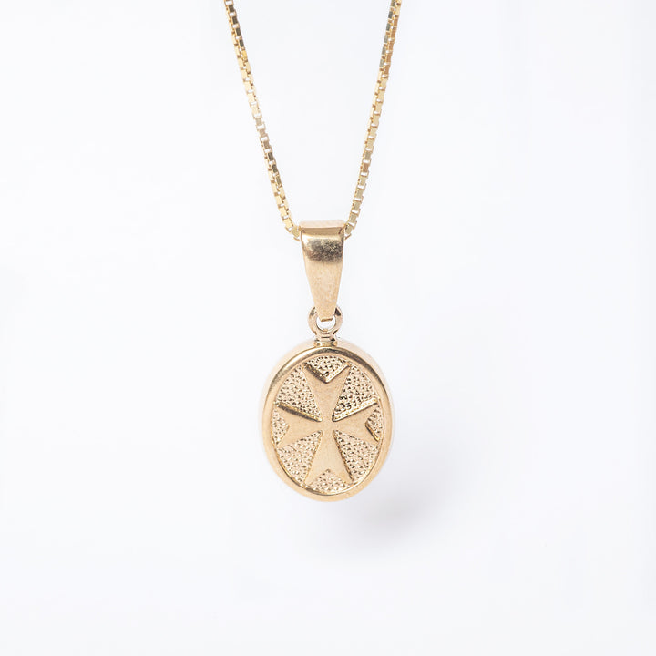 Xandru Gold pendant and its respective chain standing in the center of the image against a white background. 