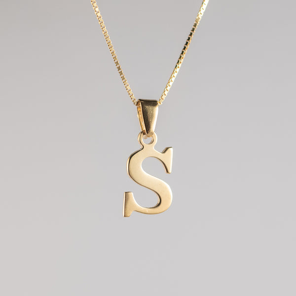A gold-plated sterling silver pendant in the shape of the letter 'S' on a chain, against a white background.