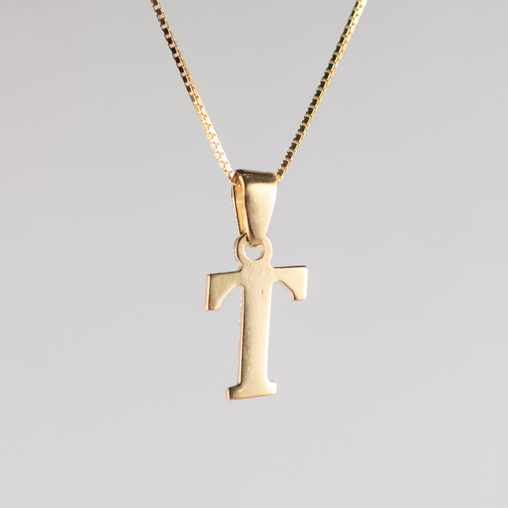A close up view of initials gold letter pendant letter T 