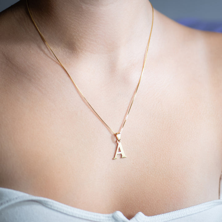woman wearing initials gold letter pendant letter a
