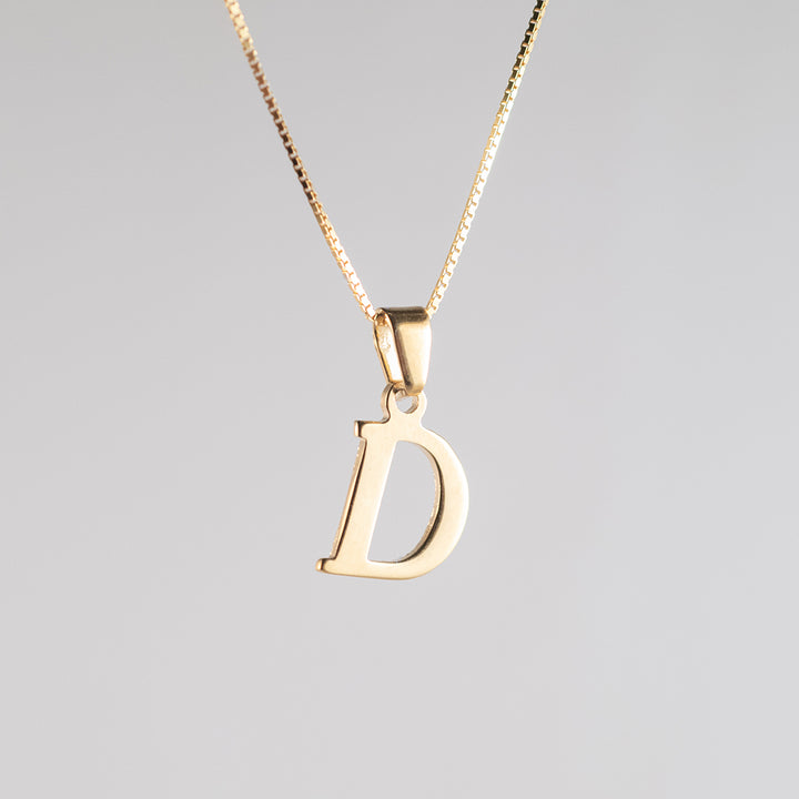 A close up view of initials gold letter pendant D letter 