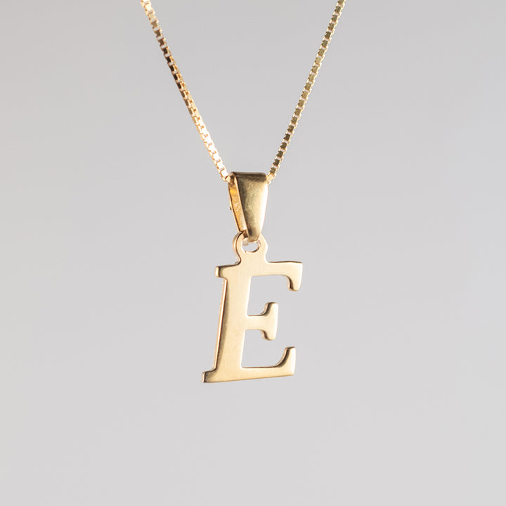 A close up view of initials gold letter pendant E letter 