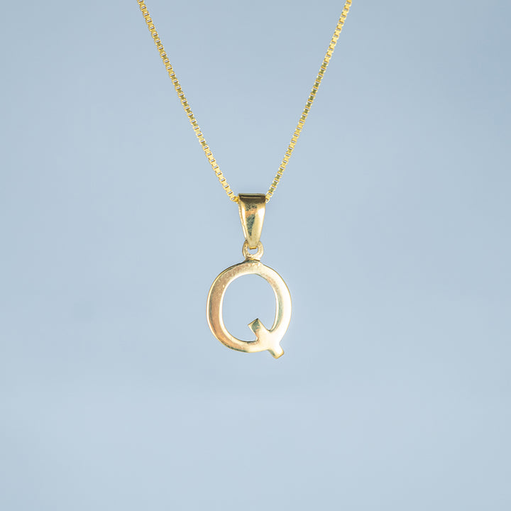 A close up view of initials gold letter pendant letter Q 