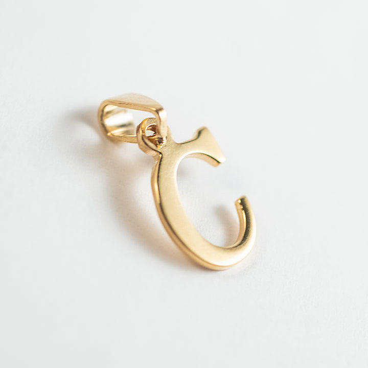 A close up view of initials gold letter pendant letter C 