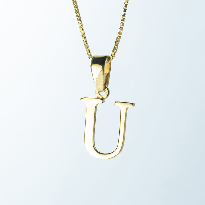 A close up view of initials gold letter pendant letter  U 