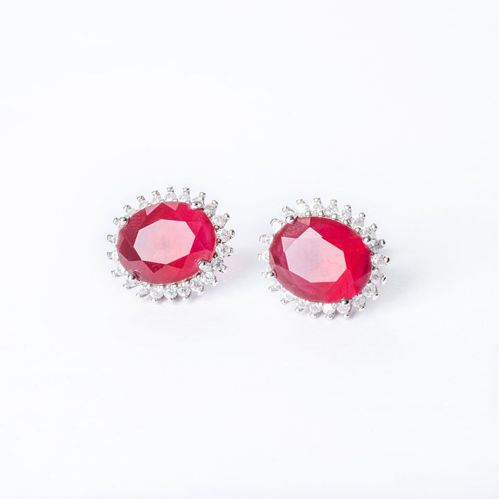 A close up view of Kate Earrings red colour stone standing in the center of the image against a white background. 
