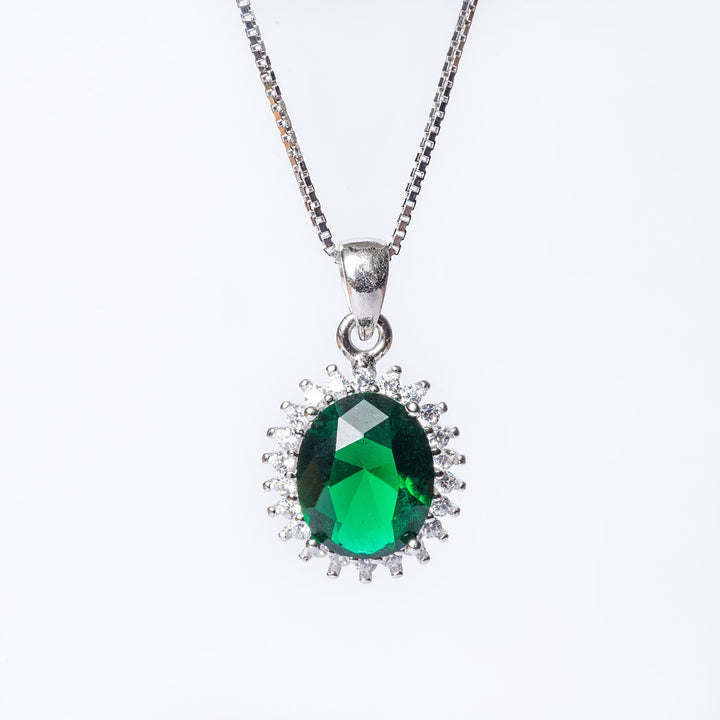 A close up view of kate necklace green stone standing in the center of the image against a white background. 