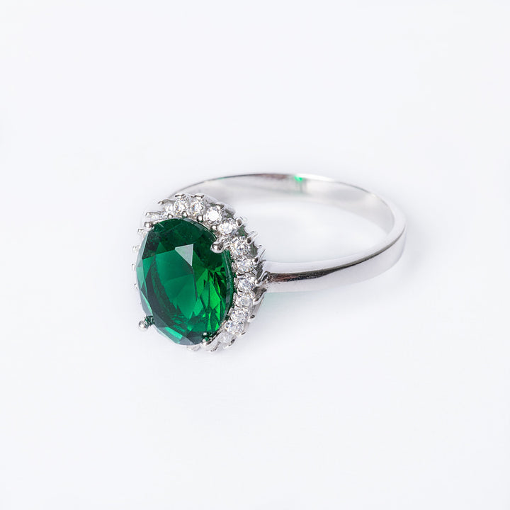 A Sterling Silver 925 ring with a green AAA Cubic Zirconia center stone surrounded by smaller zirconia crystals, set in a silver band.