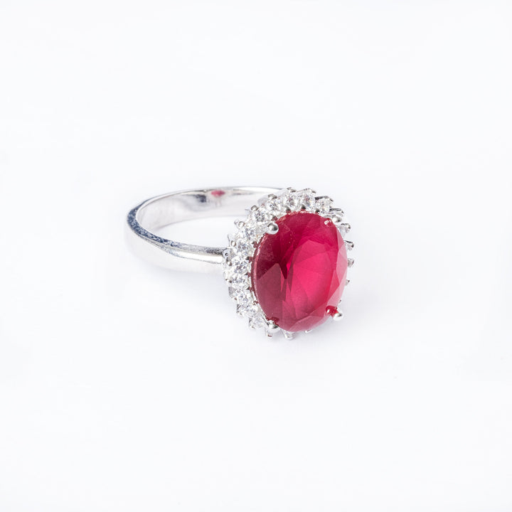 A red stone Kate Ring standing in the center of the image against a white background. 