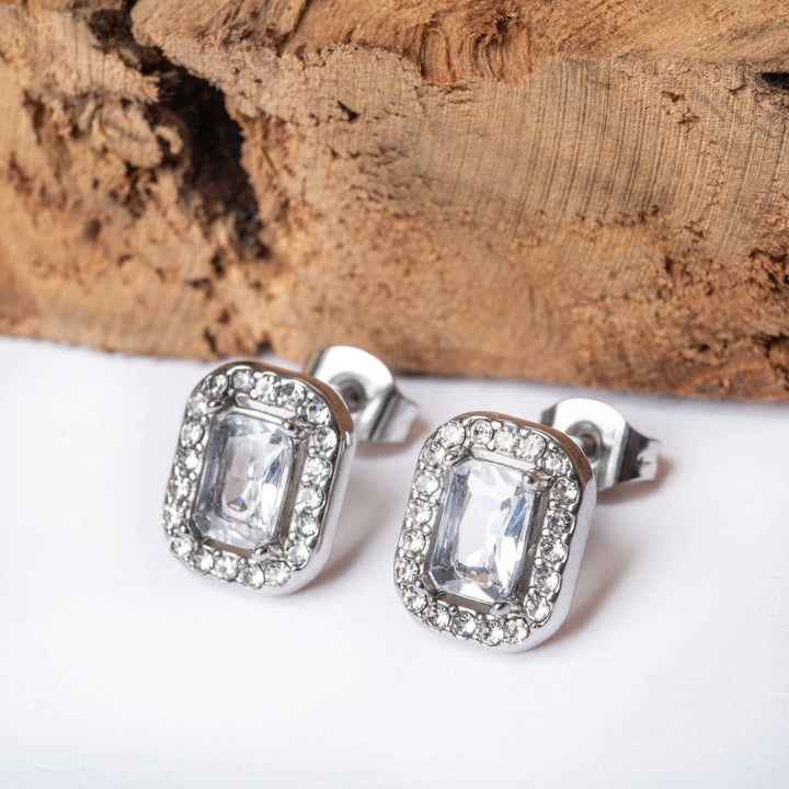 A close up view of Kristal Earrings standing in the center of the image against a white background, and piece of wood behind them. 