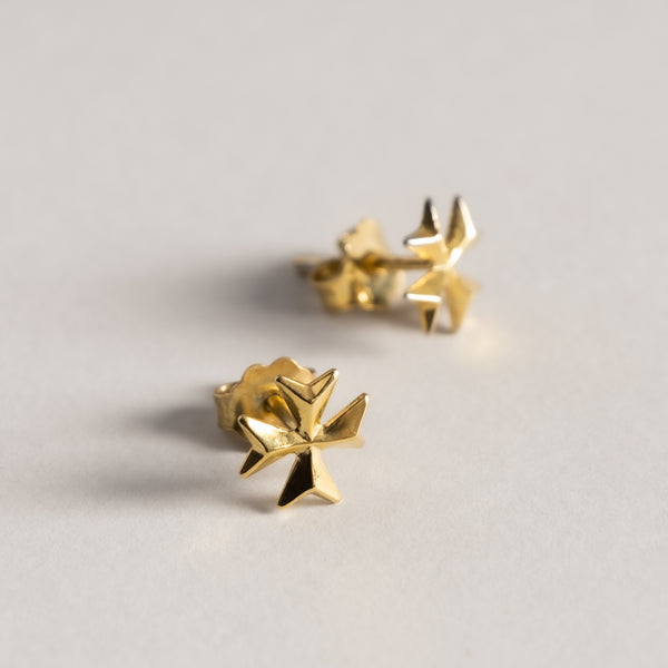 A close up view of Malta Cross Emboss Gold Stud standing in the center of the image against a white background. 