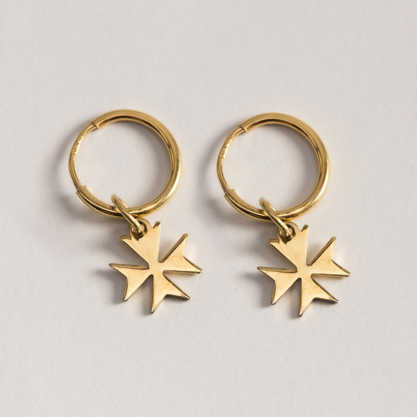 A close up view of Malta Cross Gold Huggies standing in the center of the image against a white background. 