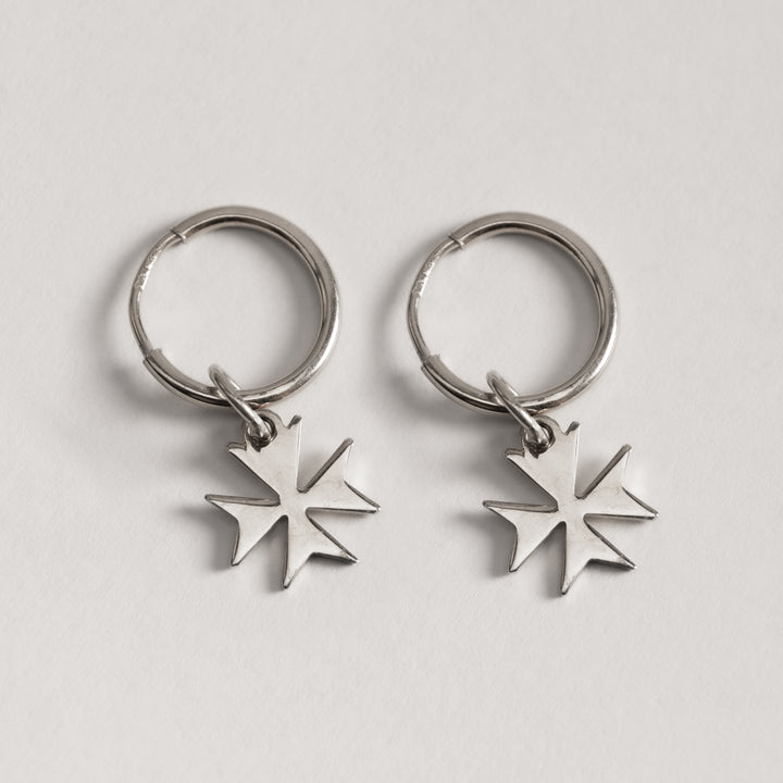 A pair of silver-colored Malta cross hoop earrings designed in the shape of a Maltese cross, displayed against a white background.