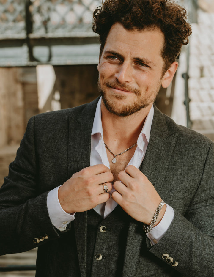 A man wearing Xandru Silver pendant. 