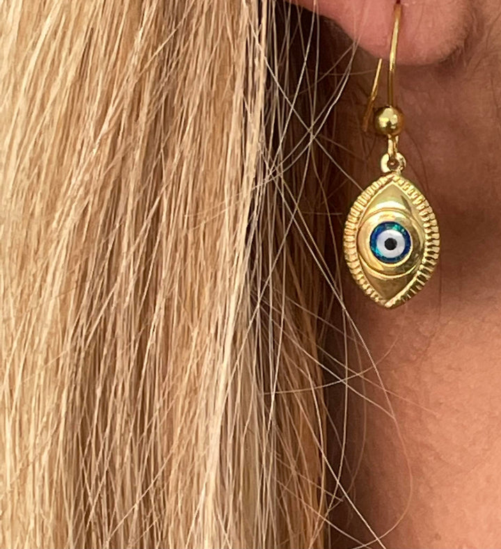 A close up view of woman wearing evil eye earring