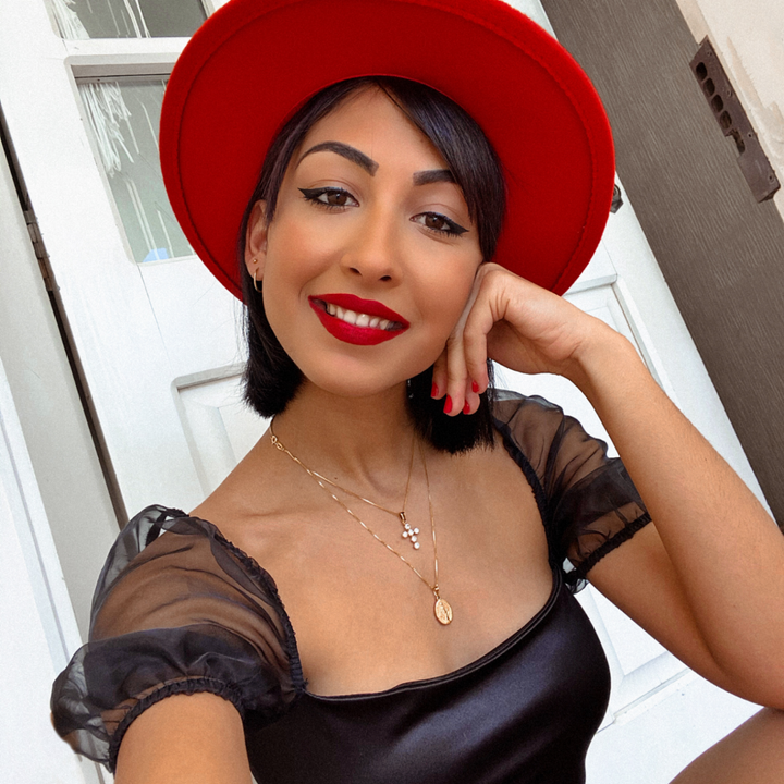 woman wearign White Zircons Cross Pendant combined with jeans sort, red hat, and black elegant tshirt 
