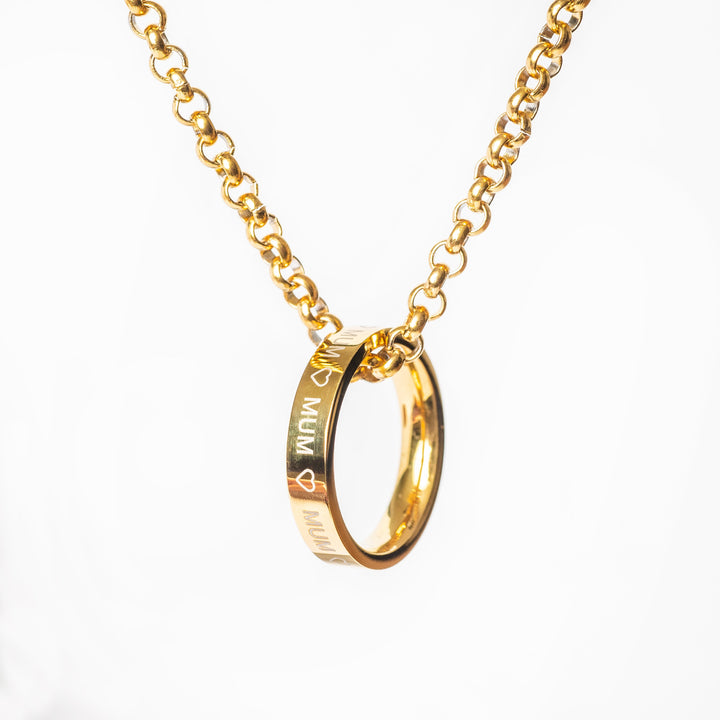 A gold-colored stainless steel ring necklace with the word 'MUM' inscribed on the ring pendant, attached to a chain.