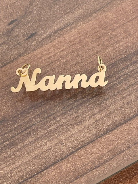 Nanna 18ct gold necklace standing in the center of the image against a brown background. 