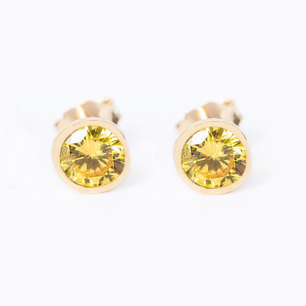 A pair of yellow gold plated silver November bird stone earrings with a citrine yellow gemstone in a sunburst design.