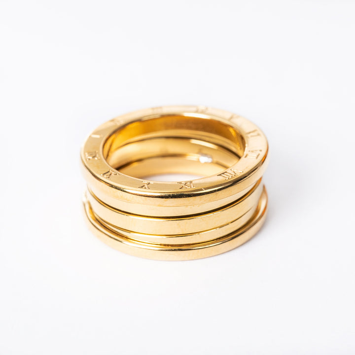 A stack of yellow gold-plated stainless steel  Omnia rings on a white background.