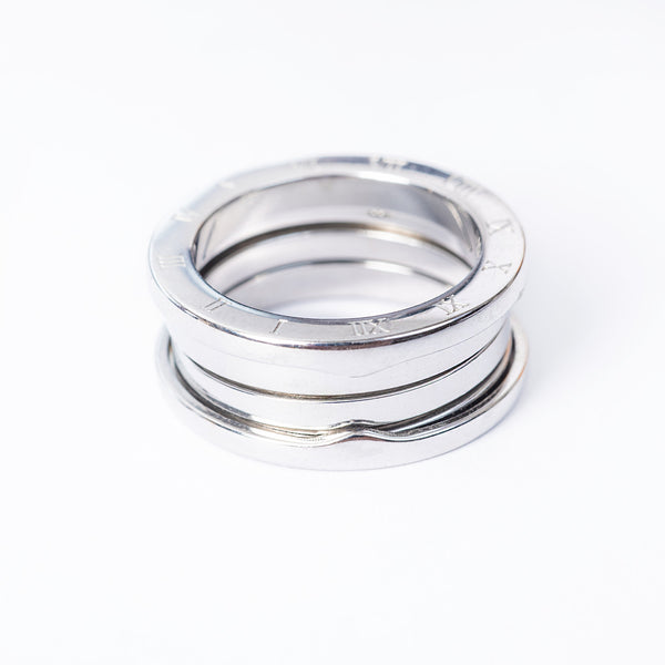 A stack of silver-plated  Omnia rings on a white background, with each ring featuring a textured surface and a bright metallic finish.
