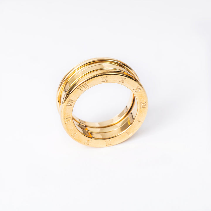 A close up view of Omnia Gold ring standing in the center of the image. 