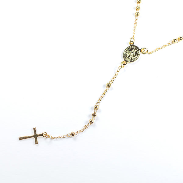 A gold-colored stainless steel rosary necklace with a cross and a medallion on a white background