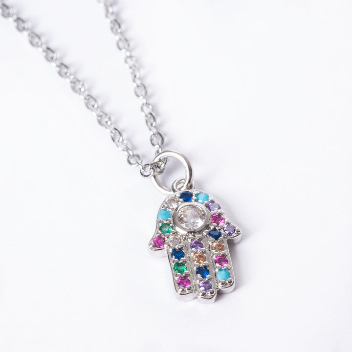 A close up view of The Hamsa Necklace standing in the center of the image against a white background. 